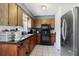 Kitchen with wooden cabinetry and a sleek black appliances at 1406 Hope Ct, Tavares, FL 32778