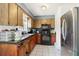 The kitchen features wooden cabinets, black appliances, and a stainless steel refrigerator at 1406 Hope Ct, Tavares, FL 32778
