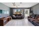 Bright living room featuring a ceiling fan, tiled floors, television, and comfortable seating area at 1406 Hope Ct, Tavares, FL 32778