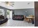 Cozy living room with tile floors, leather sofas and ceiling fan for comfortable living at 1406 Hope Ct, Tavares, FL 32778