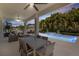Inviting covered patio with stylish outdoor seating and dining area next to a pool with cascading water feature at 14907 Guava Bay Dr, Winter Garden, FL 34787