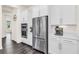 Modern kitchen with stainless steel refrigerator, built-in ovens, and white cabinets at 14907 Guava Bay Dr, Winter Garden, FL 34787