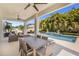 Covered patio with ample seating and dining with beautiful view of the pool and landscaping at 14907 Guava Bay Dr, Winter Garden, FL 34787