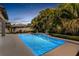 Twilight view of the resort style pool surrounded by lush landscaping, patio and furniture at 14907 Guava Bay Dr, Winter Garden, FL 34787