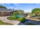 Landscaped backyard showcasing the pool, pond, and well-maintained lawn with lush greenery at 15245 Arabian Way, Montverde, FL 34756