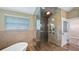 Luxurious bathroom featuring a glass-enclosed shower with a built-in bench and a soaking tub at 15245 Arabian Way, Montverde, FL 34756