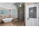 Luxurious bathroom featuring a glass-enclosed shower, soaking tub, and linen closet at 15245 Arabian Way, Montverde, FL 34756