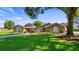 Charming single-story home with a well-manicured lawn, mature trees, and a welcoming red front door at 15245 Arabian Way, Montverde, FL 34756