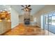 Bright living room boasts a brick fireplace, hardwood floors, and sliding doors to the patio at 15245 Arabian Way, Montverde, FL 34756