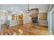 Open-concept living room featuring hardwood floors and a cozy brick fireplace at 15245 Arabian Way, Montverde, FL 34756