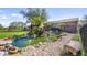 Beautifully landscaped pond featuring a rock surround, bridge, and diverse plant life at 15245 Arabian Way, Montverde, FL 34756