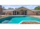 Backyard pool and patio area leading to a screened lanai, with views of the home's exterior at 15245 Arabian Way, Montverde, FL 34756