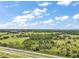 Expansive aerial view showcases vast acreage and a picturesque landscape of trees and farmland under blue skies at 1560 Ne 17Th St, Sumterville, FL 33585