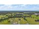 Aerial perspective shows vast acreage with home and property lines, surrounded by trees, fields, and waterfront at 1560 Ne 17Th St, Sumterville, FL 33585