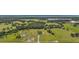 Aerial view shows expansive property with a home, pond, and large acreage with wooded areas and open fields at 1560 Ne 17Th St, Sumterville, FL 33585