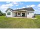 Spacious backyard featuring a covered patio, a well-maintained lawn, and the exterior of the home at 1560 Ne 17Th St, Sumterville, FL 33585
