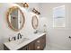 Bright bathroom featuring double sinks, marble countertop, decorative mirrors and modern lighting fixtures at 1560 Ne 17Th St, Sumterville, FL 33585