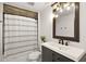 Bathroom featuring vanity, mirror with lights, toilet, and shower with a decorative shower curtain at 1560 Ne 17Th St, Sumterville, FL 33585