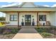Inviting farmhouse front porch with wooden beams, double doors, and charming seating creates a welcoming entrance at 1560 Ne 17Th St, Sumterville, FL 33585