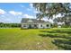 Beautiful white farmhouse with a covered porch and classic swing sits on a large, well-manicured lawn at 1560 Ne 17Th St, Sumterville, FL 33585