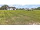 Spacious front yard features a modern white farmhouse with an expansive lawn and country-style fencing at 1560 Ne 17Th St, Sumterville, FL 33585