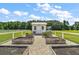 Charming white garden shed with a metal roof, set among raised garden beds at 1560 Ne 17Th St, Sumterville, FL 33585