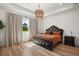 Beautiful main bedroom with tray ceilings, hardwood floors, and a decorative light fixture at 1560 Ne 17Th St, Sumterville, FL 33585