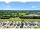Scenic aerial view showcases neighborhood homes, green spaces and clear blue skies at 1615 Navidad St, The Villages, FL 32162