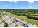 Wide aerial view of a quiet residential neighborhood nestled amongst trees and green fields at 1615 Navidad St, The Villages, FL 32162