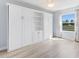 Bedroom features a large built-in wardrobe with a window and neutral walls at 1615 Navidad St, The Villages, FL 32162