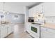 Classic white kitchen featuring updated appliances, modern countertops, and backsplash at 1615 Navidad St, The Villages, FL 32162
