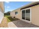 Exterior home view featuring a brick patio with sliding glass doors at 1615 Navidad St, The Villages, FL 32162