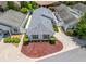 An aerial view of a well-maintained single-story home with a manicured yard and a private setting at 1713 Jadestone Ter, The Villages, FL 32162