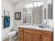 Bright bathroom featuring a wood vanity, framed mirror, and decorative towels at 1713 Jadestone Ter, The Villages, FL 32162