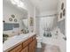 Bathroom featuring wood vanity, framed mirror, and shower with curtain at 1713 Jadestone Ter, The Villages, FL 32162