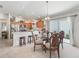 Inviting dining area featuring a glass table, decorative chairs, and an open view to the modern kitchen at 1713 Jadestone Ter, The Villages, FL 32162