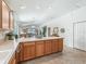 Spacious kitchen with an open layout, featuring wood cabinets and an island with countertop seating at 1713 Jadestone Ter, The Villages, FL 32162