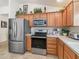 Well-appointed kitchen featuring stainless steel appliances, wood cabinets, and generous counter space at 1713 Jadestone Ter, The Villages, FL 32162
