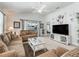 Bright living room with a large TV, neutral decor, and cozy seating arrangements at 1713 Jadestone Ter, The Villages, FL 32162