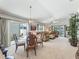 Open concept living area with dining space, a glass table, carpet, and natural light from sliding glass doors at 1713 Jadestone Ter, The Villages, FL 32162