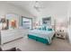 Bright main bedroom features a bed with turquoise accents, complemented by white furnishings at 1713 Jadestone Ter, The Villages, FL 32162