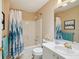 Well-lit bathroom featuring a shower-tub combo and a large mirror at 1728 Morelos Rd, The Villages, FL 32159