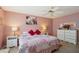Pink bedroom with ceiling fan, bedside lamps, and a floral patterned bed at 1728 Morelos Rd, The Villages, FL 32159