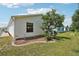 Side view of the home, showcasing well-maintained landscaping, tidy yard and an installed air conditioning unit at 1728 Morelos Rd, The Villages, FL 32159