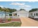 Charming single-story home with a white picket fence, lush landscaping, and a well-maintained front yard at 1728 Morelos Rd, The Villages, FL 32159