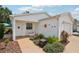 Welcoming front entrance with a charming seating area, vibrant plants, and decorative art on the home's exterior at 1728 Morelos Rd, The Villages, FL 32159