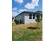 Backyard view featuring an air conditioning unit and sliding glass doors to the home's interior at 1808 Carnostie Rd, Winter Haven, FL 33884