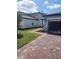 Exterior shot with brick driveway leading to a two-car garage and a well-maintained lawn at 1808 Carnostie Rd, Winter Haven, FL 33884