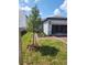 Exterior view featuring a two-car garage, manicured landscaping, and a brick driveway at 1808 Carnostie Rd, Winter Haven, FL 33884