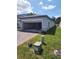Single-Gathering home featuring a two-car garage, brick driveway, and well-maintained landscaping at 1808 Carnostie Rd, Winter Haven, FL 33884